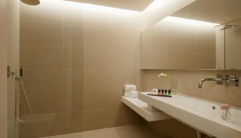 Bathroom at O&B Athens Boutique Hotel, a gay-friendly hotel. Features shower, sink, mirror, toiletries. Modern design for gay travelers.