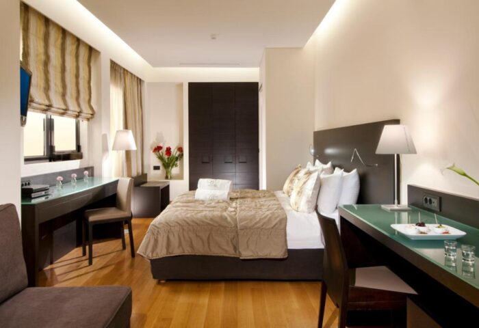 O&B Athens Boutique Hotel room. Gay-friendly hotel with modern design, desk, bed, and closet. Ideal for gay travel in Athens, Greece.