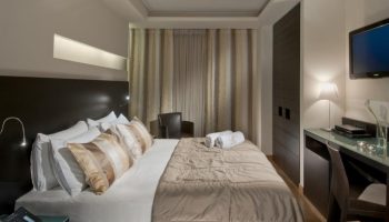 O&B Athens Boutique Hotel room. Gay-friendly hotel bedroom with bed, desk, TV, and closet. Modern design for gay travelers in Athens.