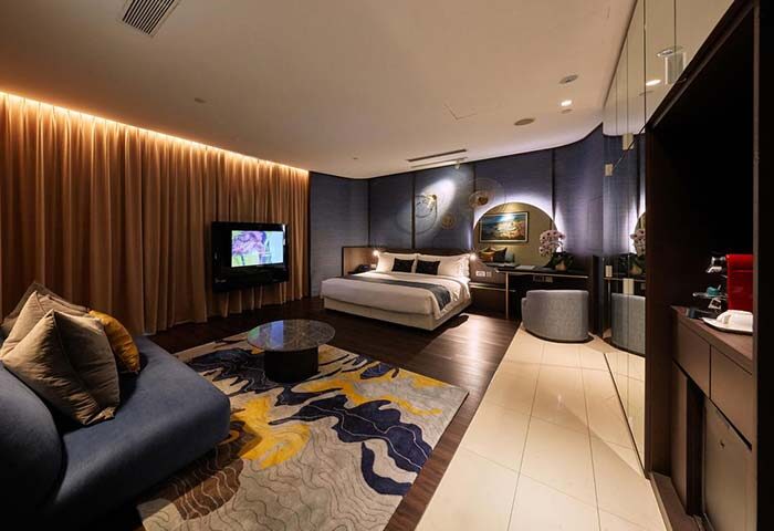 ONE15 Marina Sentosa Cove Singapore gay-friendly hotel room. Modern design with bed, couch, TV, and stylish decor. Luxury travel.
