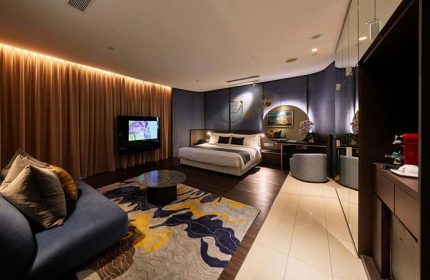 ONE15 Marina Sentosa Cove Singapore gay-friendly hotel room. Modern design with bed, couch, TV, and stylish decor. Luxury travel.