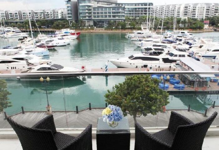 ONE15 Marina Sentosa Cove Singapore: View from a gay-friendly hotel balcony overlooking the marina with yachts and waterfront buildings.