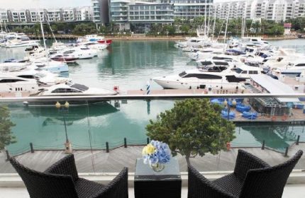 ONE15 Marina Sentosa Cove Singapore: View from a gay-friendly hotel balcony overlooking the marina with yachts and waterfront buildings.