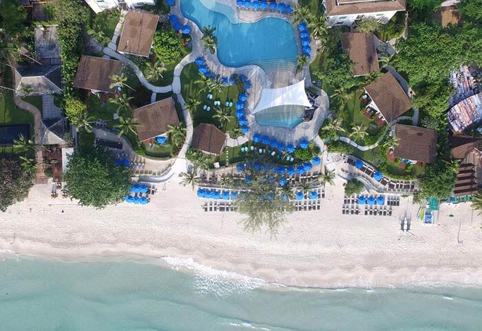 Aerial view of OZO Chaweng Samui, a gay-friendly hotel. Beachfront resort with pool, bungalows, and sun loungers. Tropical paradise.