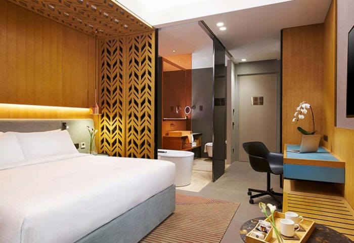 Oasia Hotel Downtown Singapore room. Gay-friendly Far East Hospitality hotel with bed, desk, and bathroom. Modern design for gay travel.