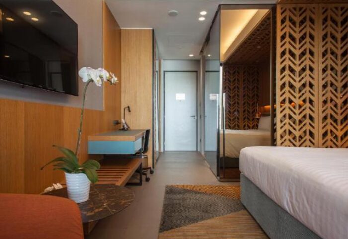 Oasia Hotel Downtown Singapore room. Gay-friendly hotel by Far East Hospitality. Modern design, desk, bed, and decorative screen.