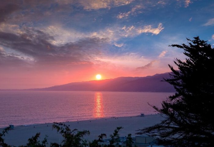 Sunset at Oceana Santa Monica, LXR Hotels & Resorts, a gay-friendly hotel. Beach view with pink and blue sky. Gay travel destination.