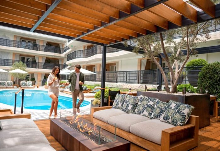 Oceana Santa Monica LXR Hotels & Resorts outdoor pool. Couple at gay-friendly hotel with fire pit, lounge area. Luxury Santa Monica travel.