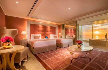 Okada Manila gay-friendly hotel room with two beds, sunset view, and bathtub. Luxurious interior design for gay travelers.