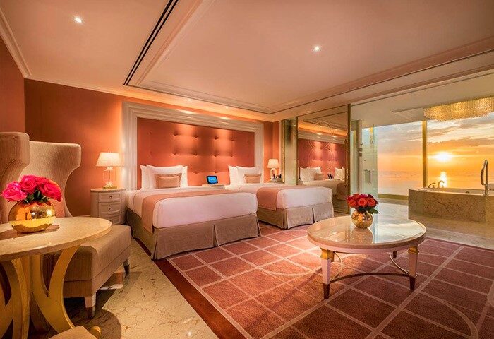 Okada Manila gay-friendly hotel room with two beds, sunset view, and bathtub. Luxurious interior design for gay travelers.