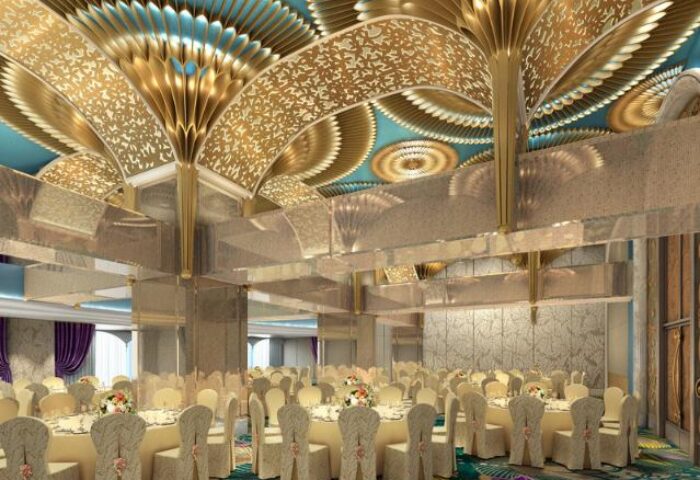 Okada Manila's gay-friendly hotel ballroom. The event space features round tables with floral centerpieces and an ornate gold ceiling.