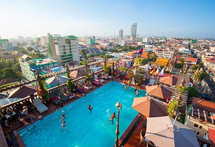 Okay Boutique Hotel's rooftop pool, a gay-friendly hotel in Phnom Penh. City views, sunbathers, and swimmers create a relaxing atmosphere.