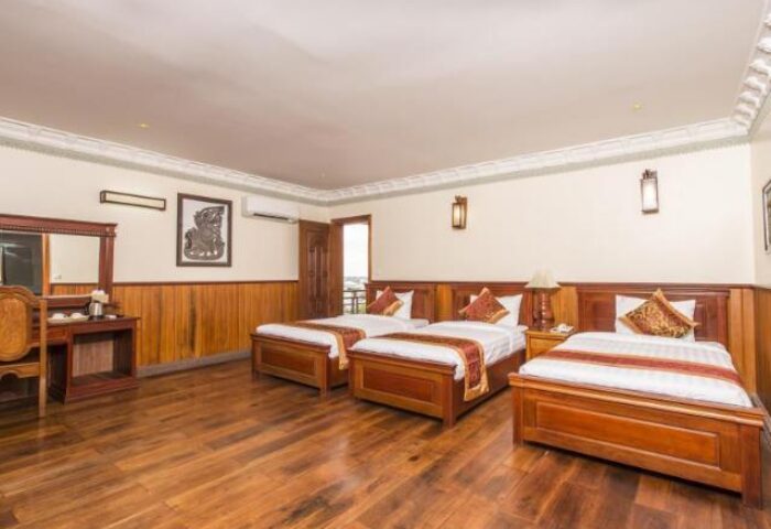 Okay Boutique Hotel gay-friendly room with 3 beds. This hotel is a great choice for gay travelers. The room has a wooden floor.