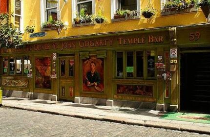 Oliver St. John Gogarty's Hostel, a gay-friendly hotel in Dublin's Temple Bar. Yellow facade, green trim, and flower boxes. A popular spot.