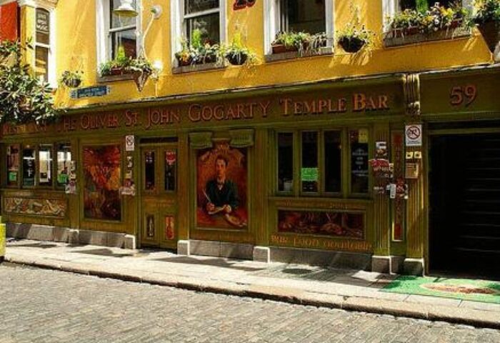 Oliver St. John Gogarty's Hostel, a gay-friendly hotel in Dublin's Temple Bar. Yellow facade, green trim, and flower boxes. A popular spot.