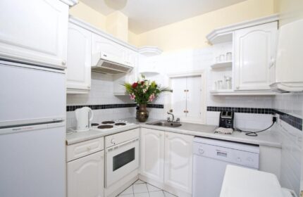 Oliver St. John Gogarty's Hostel kitchen. Gay-friendly hotel with white appliances, cabinets, & tiled backsplash. Dublin hostel for gay travelers.