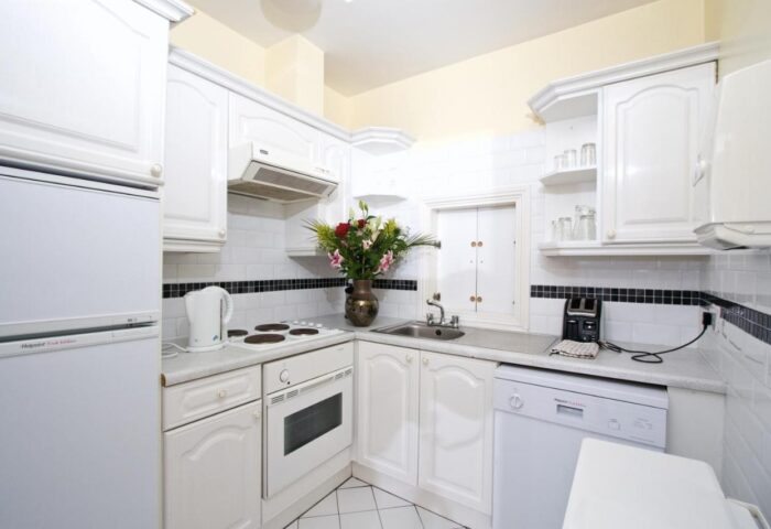 Oliver St. John Gogarty's Hostel kitchen. Gay-friendly hotel with white appliances, cabinets, & tiled backsplash. Dublin hostel for gay travelers.