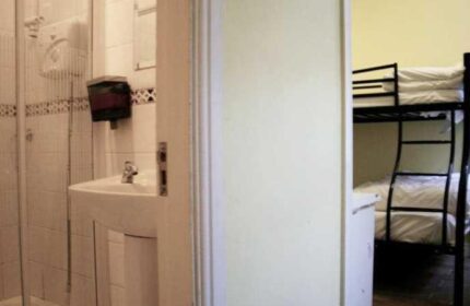Oliver St. John Gogarty's Hostel view. Bathroom with shower and sink, bunk beds in the room. Gay-friendly hotel for gay men travelers.