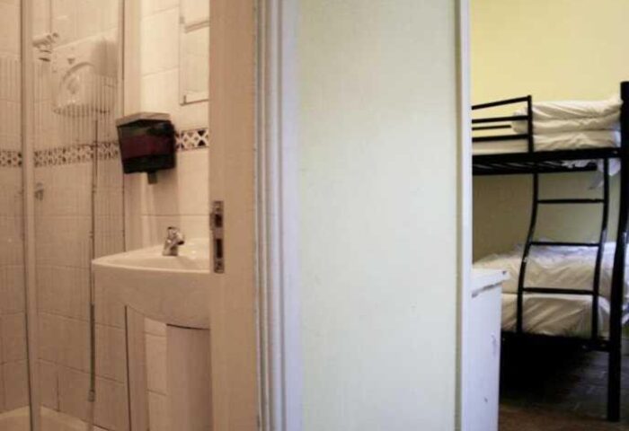 Oliver St. John Gogarty's Hostel view. Bathroom with shower and sink, bunk beds in the room. Gay-friendly hotel for gay men travelers.