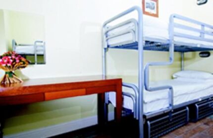 Oliver St. John Gogarty's Hostel dorm room. Bunk beds, desk, and flowers in a gay-friendly hotel. Travel advice for gay men.