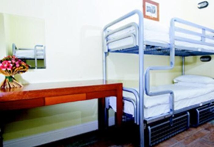 Oliver St. John Gogarty's Hostel dorm room. Bunk beds, desk, and flowers in a gay-friendly hotel. Travel advice for gay men.