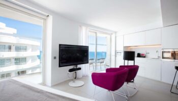 One Ibiza Suites gay-friendly hotel room. Modern design, sea view, balcony, TV, and kitchenette. Ideal for gay travel in Ibiza.