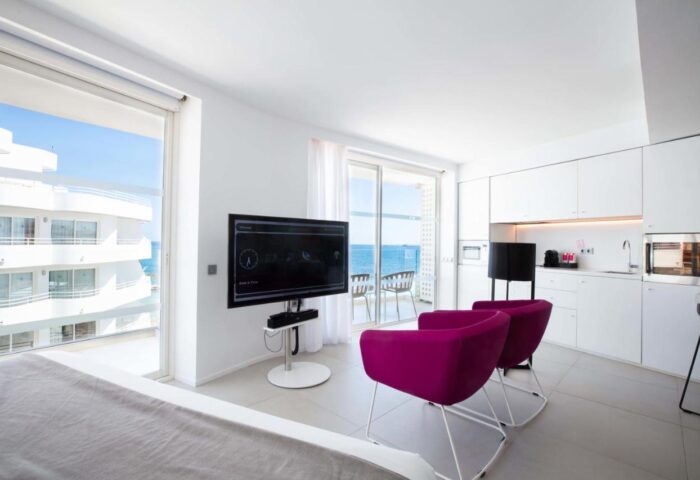 One Ibiza Suites gay-friendly hotel room. Modern design, sea view, balcony, TV, and kitchenette. Ideal for gay travel in Ibiza.