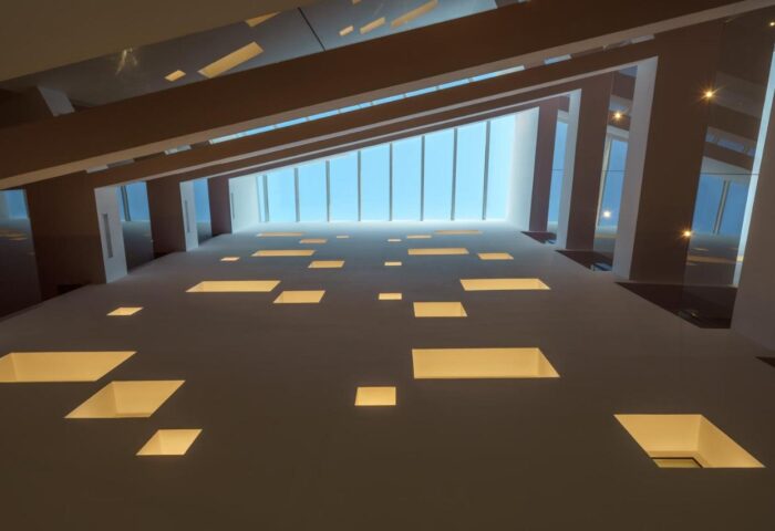 Interior of One Ibiza Suites, a gay-friendly hotel. View of the ceiling with rectangular light fixtures and a skylight. Modern architecture.