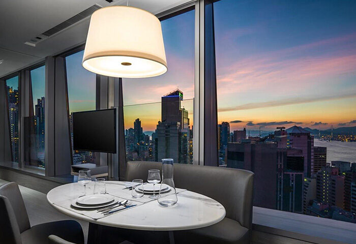 One96 Gay-Friendly Hotel: Dining area with city view at sunset. Modern design, perfect for gay travelers seeking stylish accommodations.