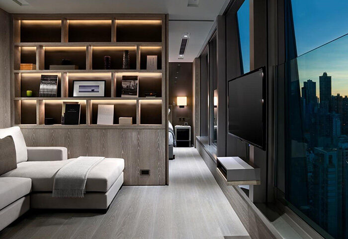 One96, a gay-friendly hotel: Modern room interior with a sofa, shelves, TV, and a city view. Ideal for gay men's travel.