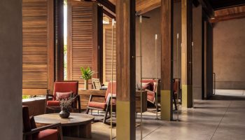 One&Only Mandarina gay-friendly hotel interior. Lounge area with wooden pillars, shutters, and furniture. Upscale travel for gay men.