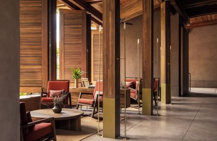 One&Only Mandarina gay-friendly hotel interior. Lounge area with wooden pillars, shutters, and furniture. Upscale travel for gay men.