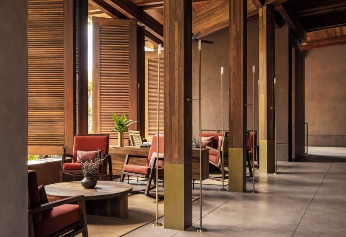 One&Only Mandarina gay-friendly hotel interior. Lounge area with wooden pillars, shutters, and furniture. Upscale travel for gay men.