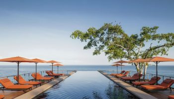 One&Only Mandarina gay-friendly hotel pool view. Infinity pool, ocean, lounge chairs, and umbrellas offer luxury for gay travelers.