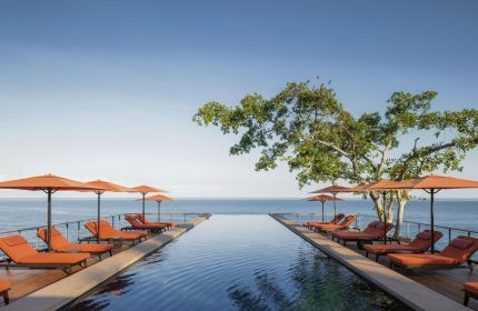 One&Only Mandarina gay-friendly hotel pool view. Infinity pool, ocean, lounge chairs, and umbrellas offer luxury for gay travelers.