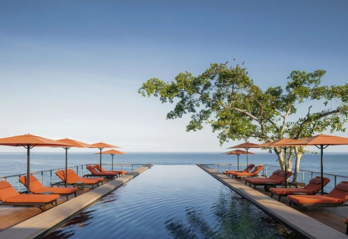 One&Only Mandarina gay-friendly hotel pool view. Infinity pool, ocean, lounge chairs, and umbrellas offer luxury for gay travelers.