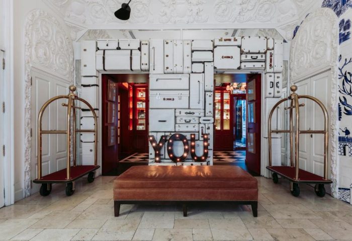 Only YOU Hotel Atocha's lobby. Luggage wall decor, YOU sign, and bellhop carts. Gay-friendly boutique hotel in Madrid for gay men travel.
