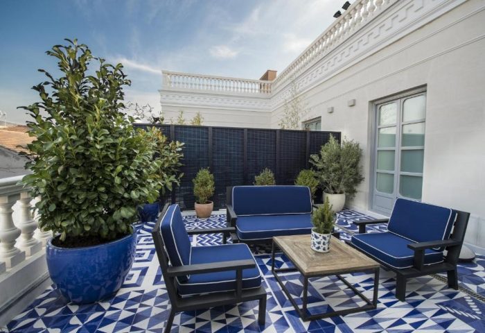 Only YOU Hotel Atocha's stylish terrace. Gay-friendly hotel in Madrid with blue & white patterned tiles, plants, and modern outdoor furniture.