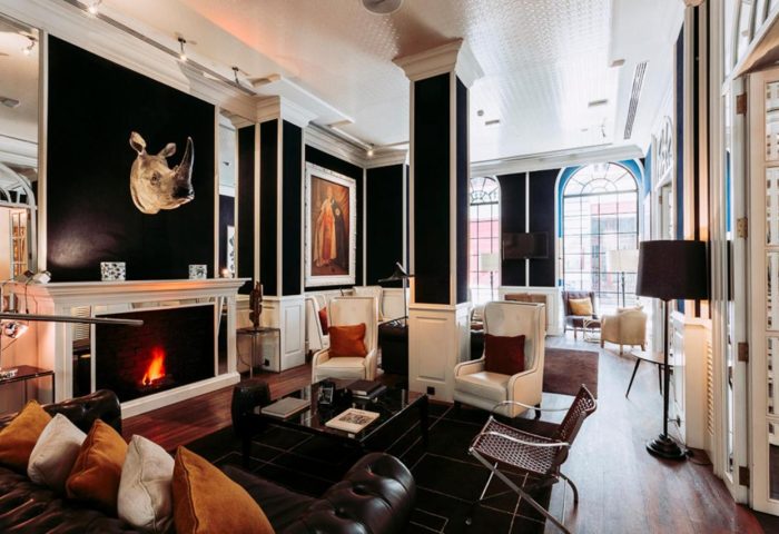 Only YOU Hotel Atocha's gay-friendly boutique hotel interior. A stylish lounge area with fireplace, rhino head decor, and comfortable seating.
