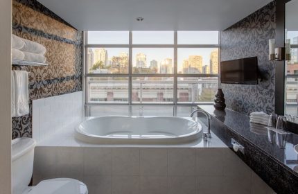 Opus Hotel's bathroom with tub, city view. Gay-friendly hotel offers luxurious accommodations for gay men, ensuring a comfortable stay.