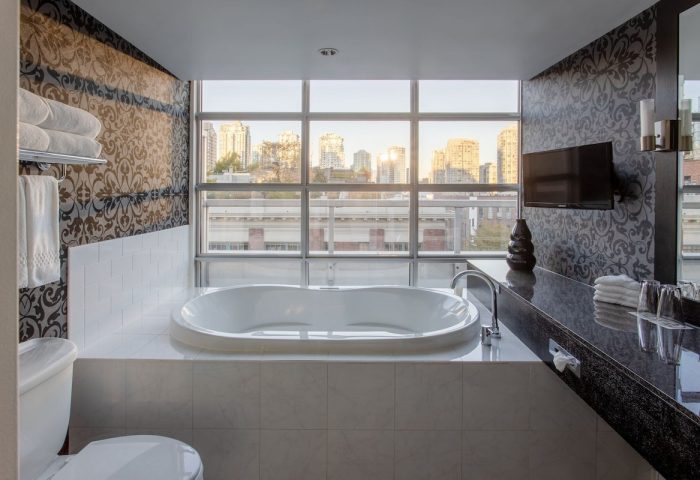 Opus Hotel's bathroom with tub, city view. Gay-friendly hotel offers luxurious accommodations for gay men, ensuring a comfortable stay.