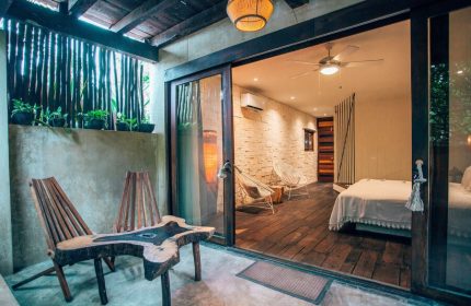 Orchid Beach House Adults Only room. Gay-friendly hotel with patio, unique wood furniture, and bedroom view. Ideal for gay travel & relaxation.