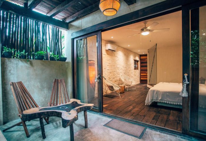 Orchid Beach House Adults Only room. Gay-friendly hotel with patio, unique wood furniture, and bedroom view. Ideal for gay travel & relaxation.