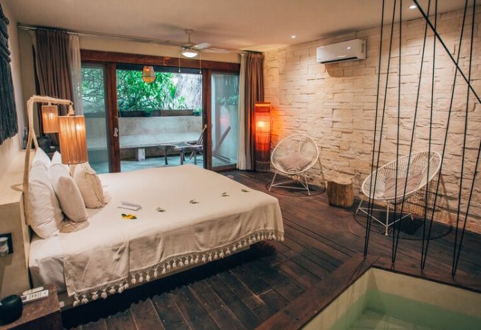 Orchid Beach House Adults Only gay-friendly hotel room. Bedroom with king bed, chairs, and private balcony. Gay travel lodging.