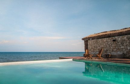 Our Habitas Tulum gay-friendly hotel: Poolside view with ocean backdrop. Relaxing vacation spot for gay men in Tulum, Mexico.