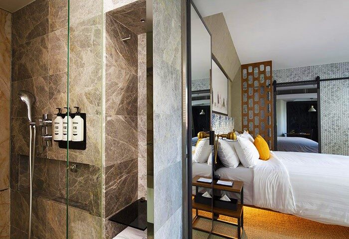 Ovolo Central Hotel room view. Modern design, shower with marble tiles, bed with white linens. Gay-friendly hotel for gay men travelers.
