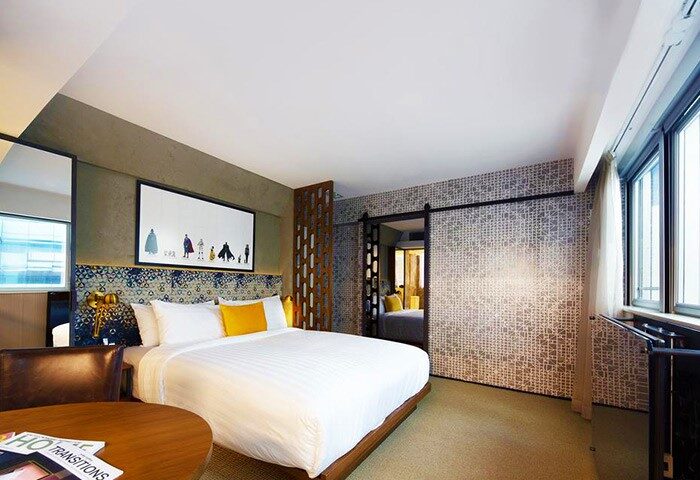 Ovolo Central hotel room. Gay-friendly hotel with a bed, table, and artwork. Modern design makes it a great place for gay men to stay.
