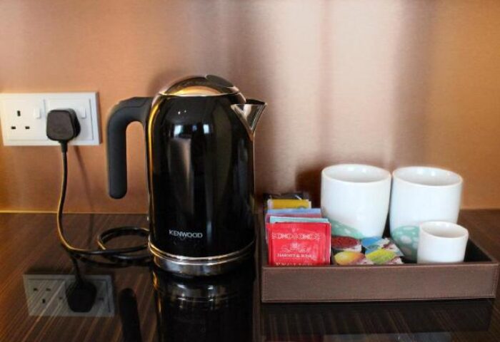Ovolo Central gay-friendly hotel room detail: Kenwood kettle, tea, and cups on a tray. Modern amenities for LGBTQ+ travelers in Hong Kong.
