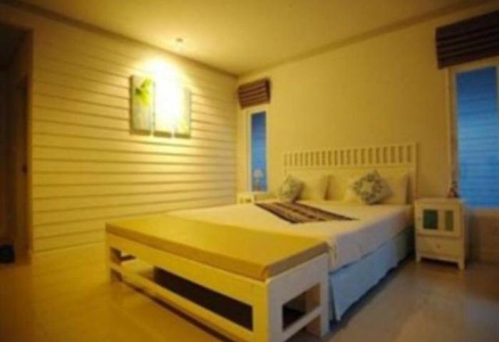 P.P. Blue Sky Resort room. Gay-friendly hotel bedroom with double bed, bench, and bedside table. Ideal for gay men's travel in Thailand.