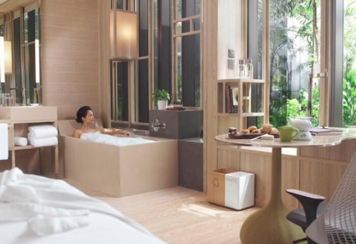 PARKROYAL COLLECTION Pickering Singapore gay-friendly hotel room. Woman relaxes in a tub with a view. Luxury travel in Singapore.
